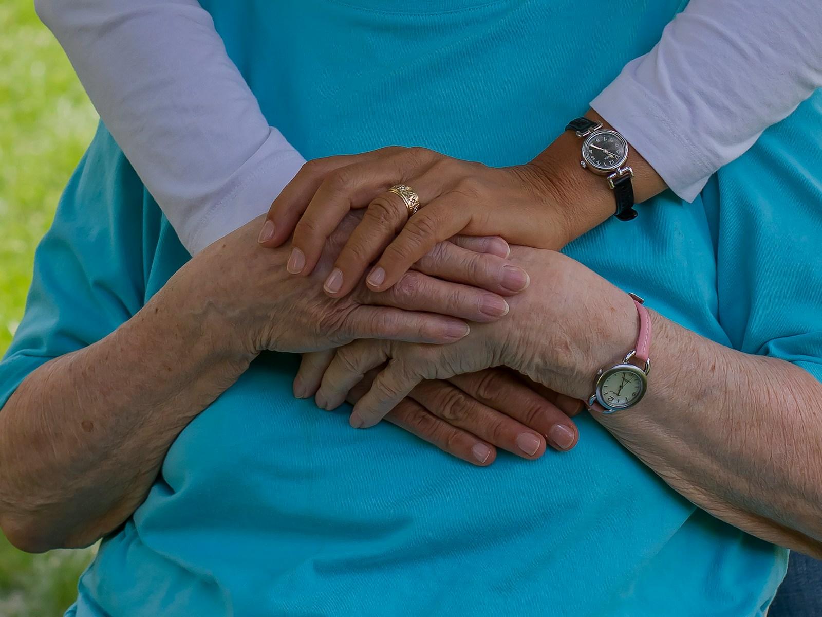 A caregiver holding a senior's hands, present and unhurried